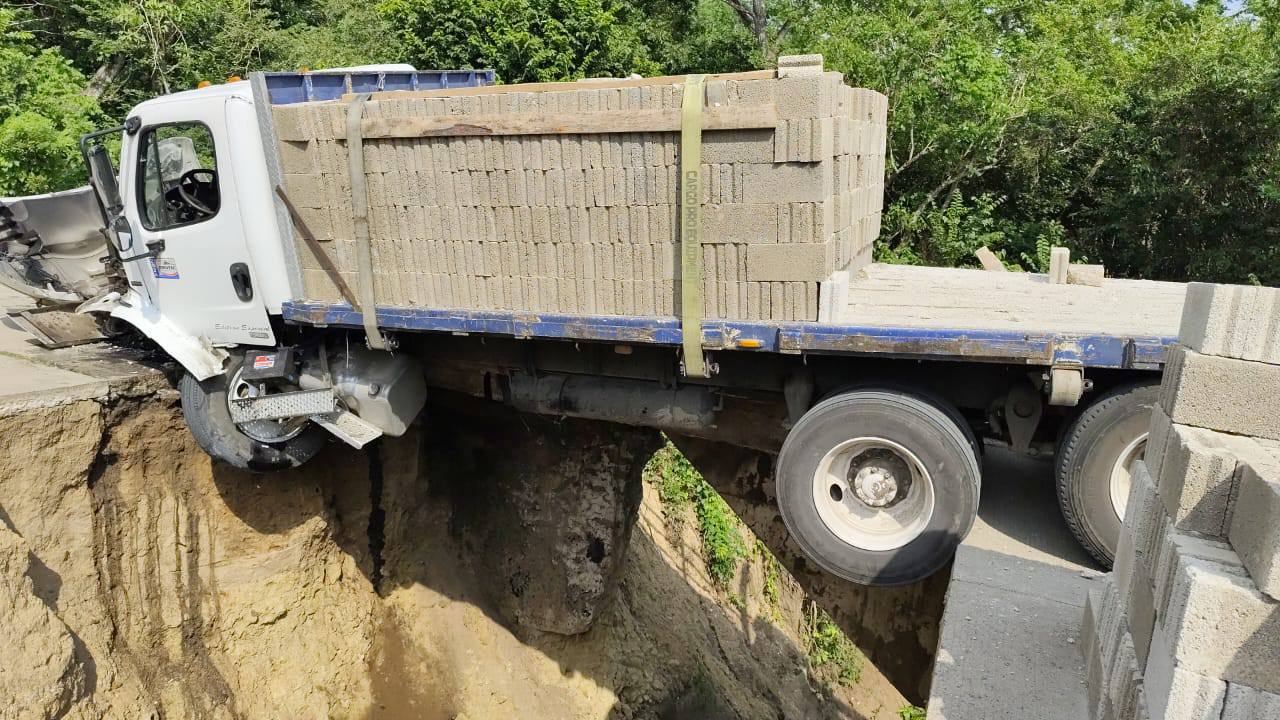 Camión de carga queda suspendido al aire tras el colapso del pavimento entre Nacaxtle y Ahuachapan en San Andrés Tuxtla.